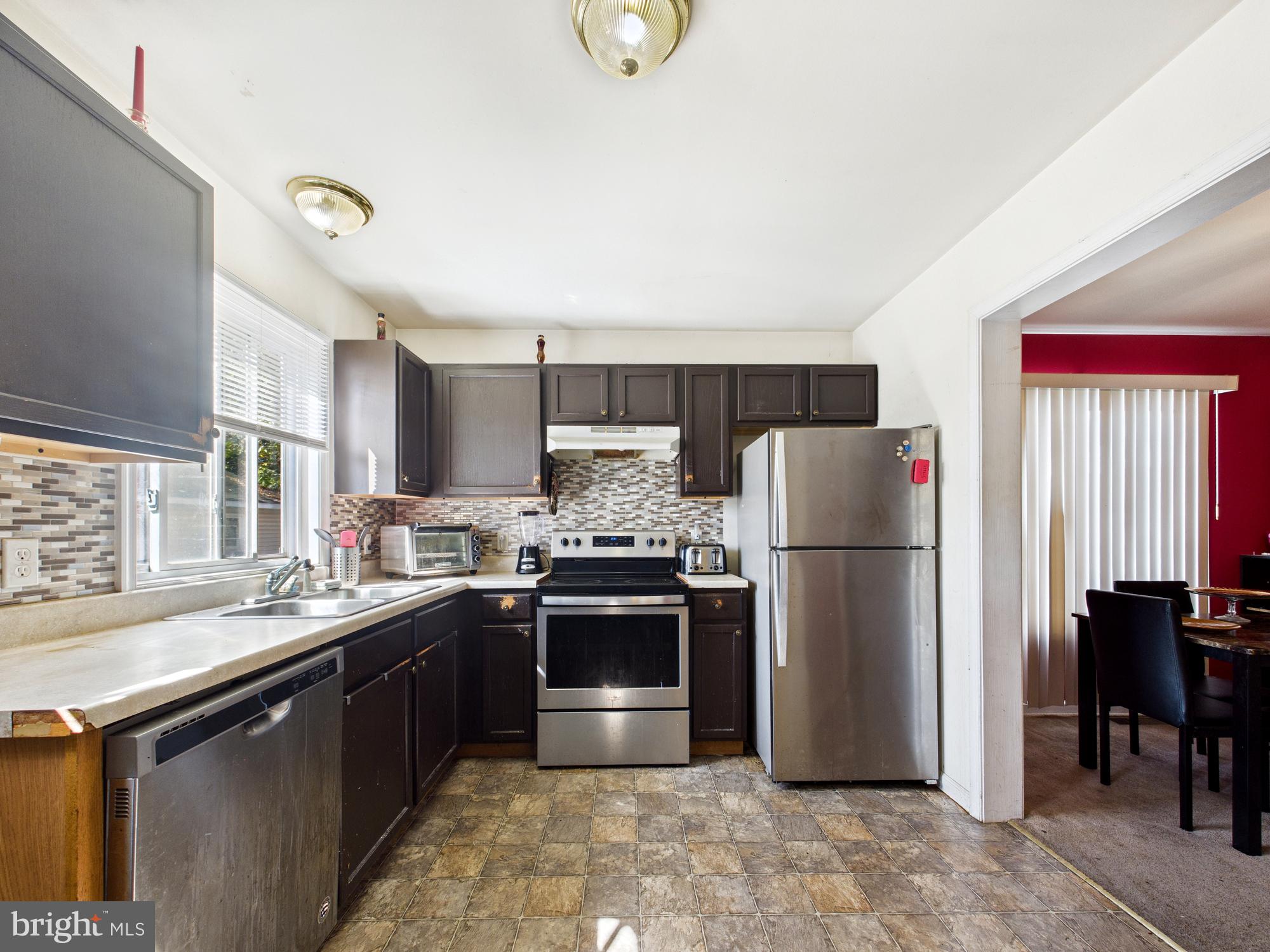 1176 West 6th Street Laurel, DE 19956 - Photo 33 of 42 a kitchen with a sink a refrigerator and a stove top oven