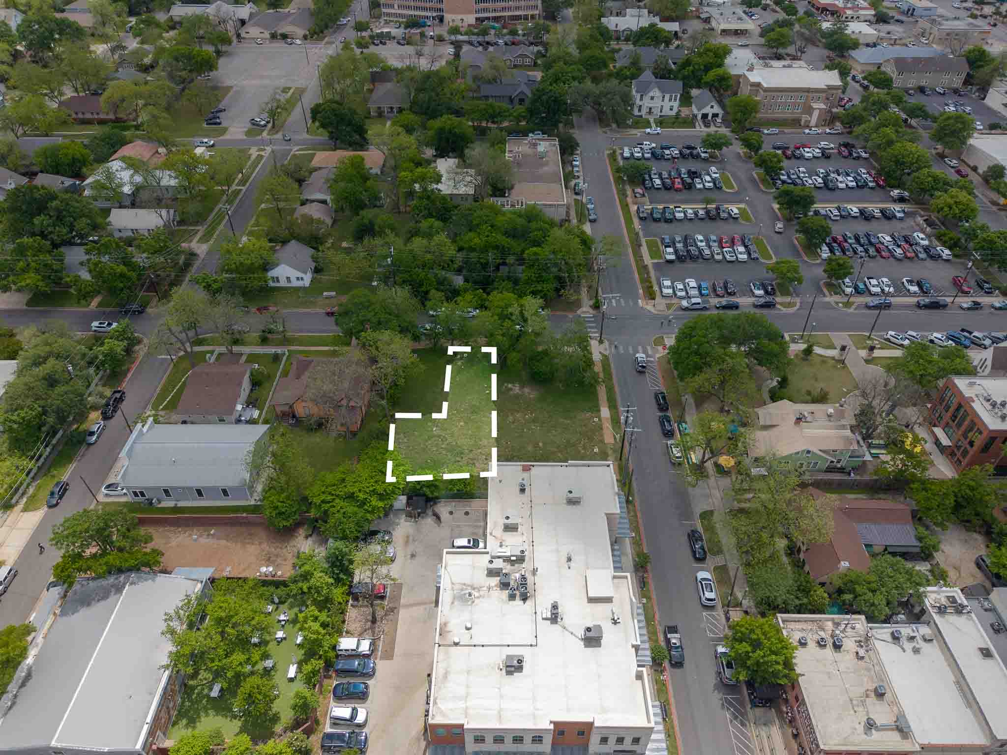 203 East 9th Street Georgetown, TX 78626 - Photo 4 of 4 Grassed lot with mature trees, bordered by established buildings and paved streets