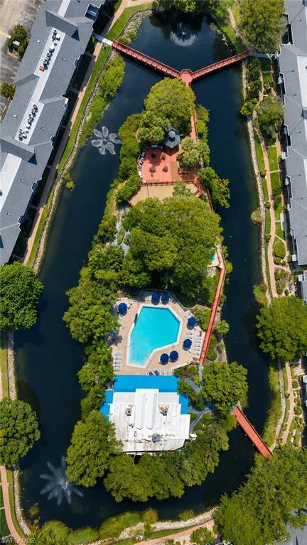 600 Neapolitan Way, Unit 449 Naples, FL 34103 - Photo 34 of 44 Central island with a large swimming pool, surrounding lounge seating, and an adjacent building featuring a blue roof