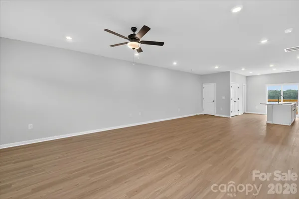 a view of empty room with wooden floor and window