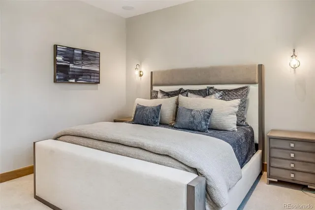 a bedroom with a bed and a lamp on dresser