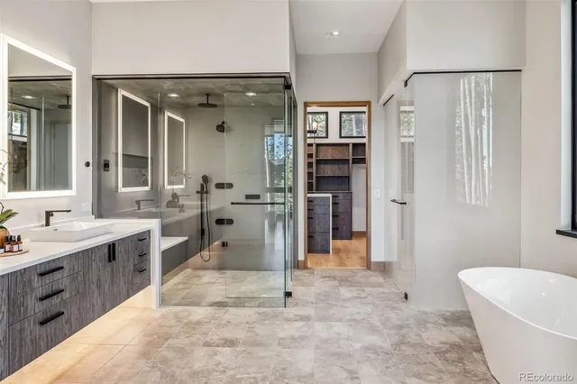 a bathroom with a tub sink and mirror