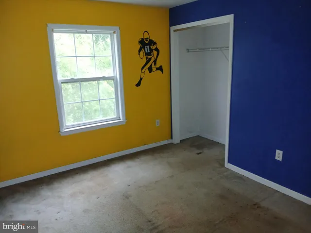 an empty room with windows and closet