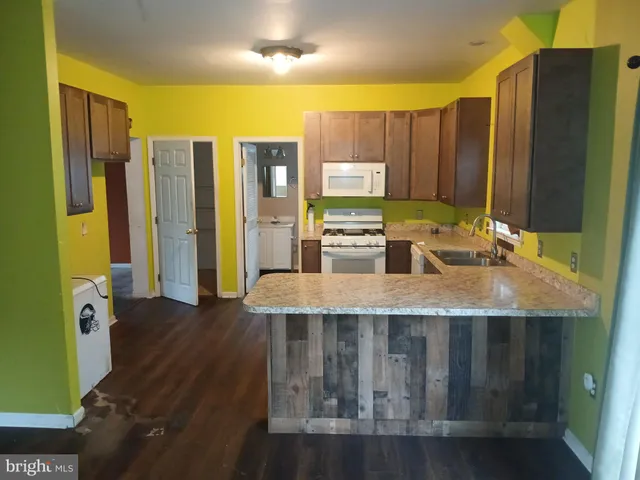 a kitchen with kitchen island granite countertop a stove a sink and a refrigerator