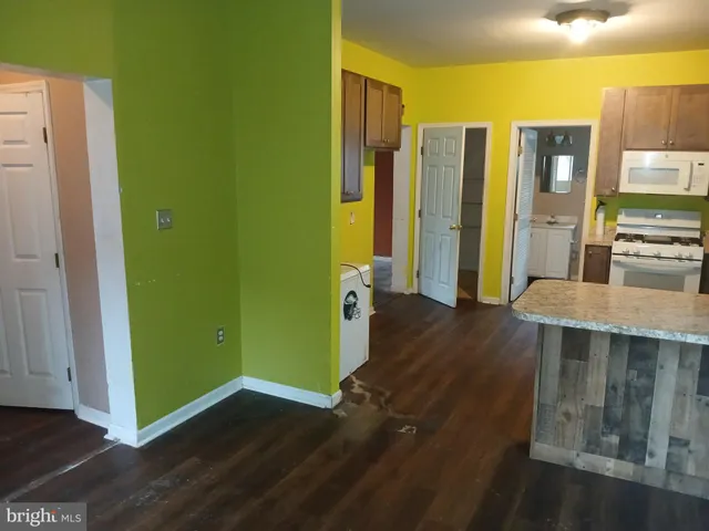 a view of a kitchen with furniture and wooden floor