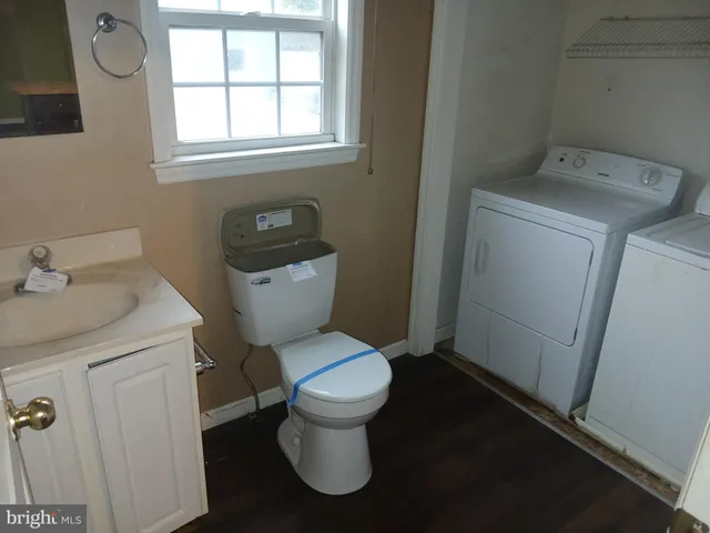 a white toilet sitting next to a bathroom sink and vanity