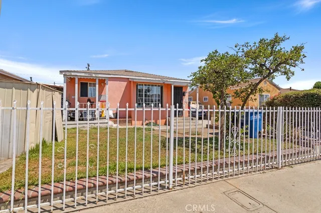a view of a house with a small yard and wooden fence