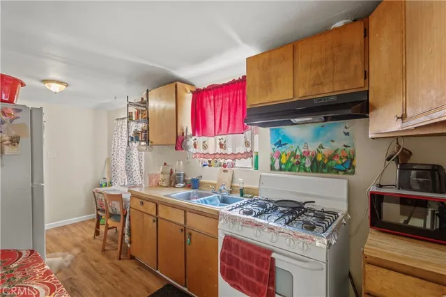 a kitchen with stainless steel appliances granite countertop a stove a sink dishwasher and cabinets with wooden floor