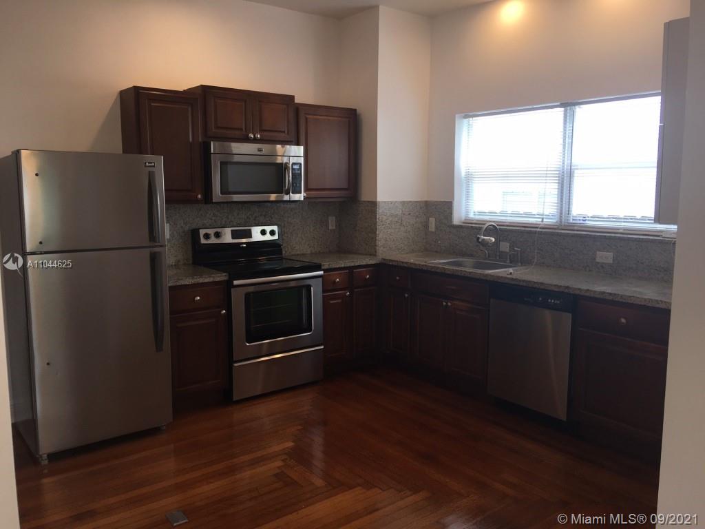410 Southwest 22nd Road Miami, FL 33129 - Photo 14 of 37 a kitchen with granite countertop a refrigerator stove and microwave