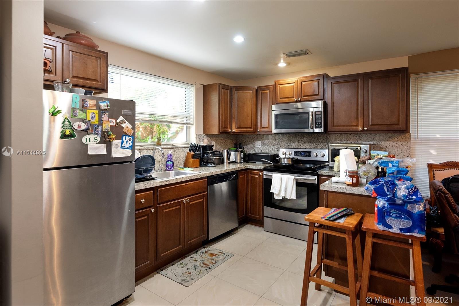410 Southwest 22nd Road Miami, FL 33129 - Photo 25 of 37 a kitchen with stainless steel appliances granite countertop a refrigerator a stove a sink and a microwave