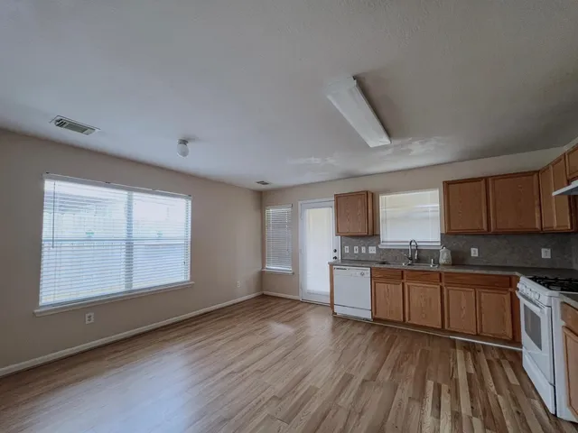 a kitchen with stainless steel appliances granite countertop wooden cabinets a stove top oven a sink and dishwasher