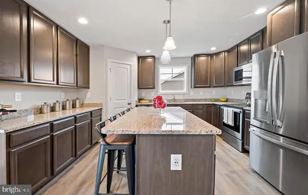 a kitchen with stainless steel appliances granite countertop a sink refrigerator and cabinets