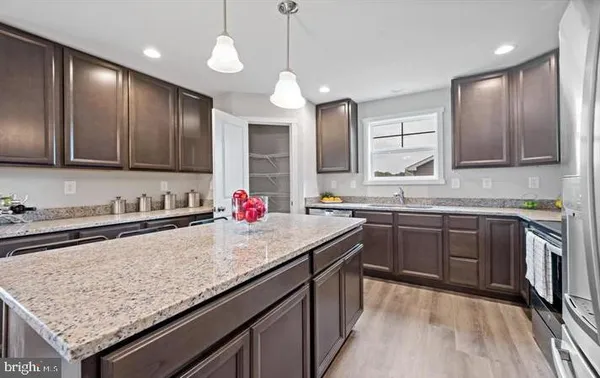 a kitchen with granite countertop stainless steel appliances a sink stove and cabinets