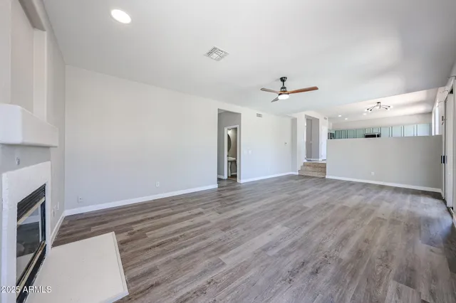 an empty room with wooden floor and a fireplace