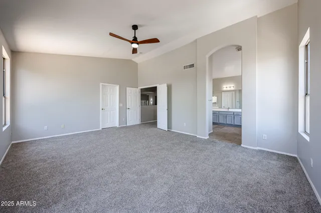 a view of a livingroom with a ceiling fan & entryway