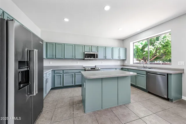 a kitchen with stainless steel appliances granite countertop a refrigerator and a sink