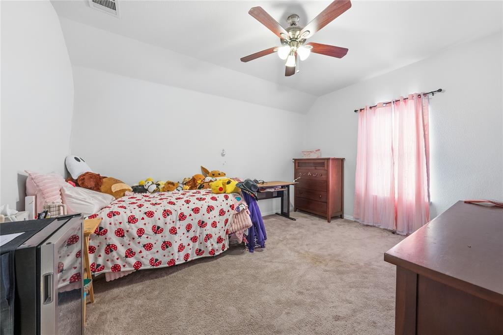 4542 Kipling Avenue Aubrey, TX 76227 - Photo 22 of 34 a bedroom with a bed and a chandelier