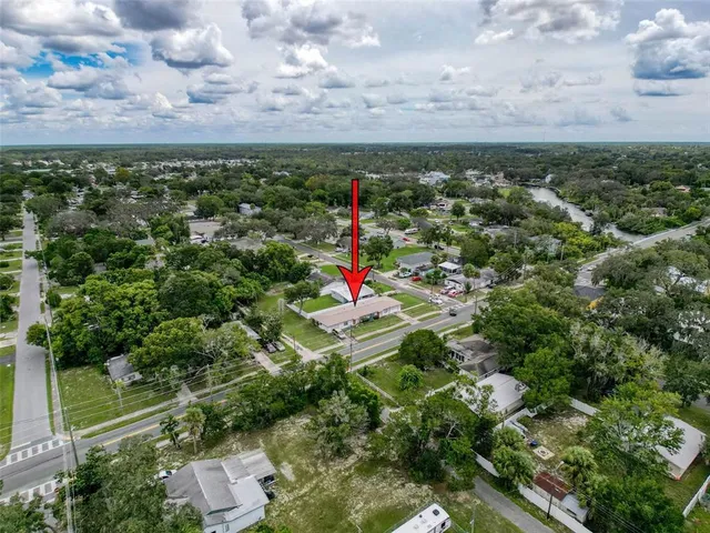 an aerial view of residential houses with outdoor space and trees