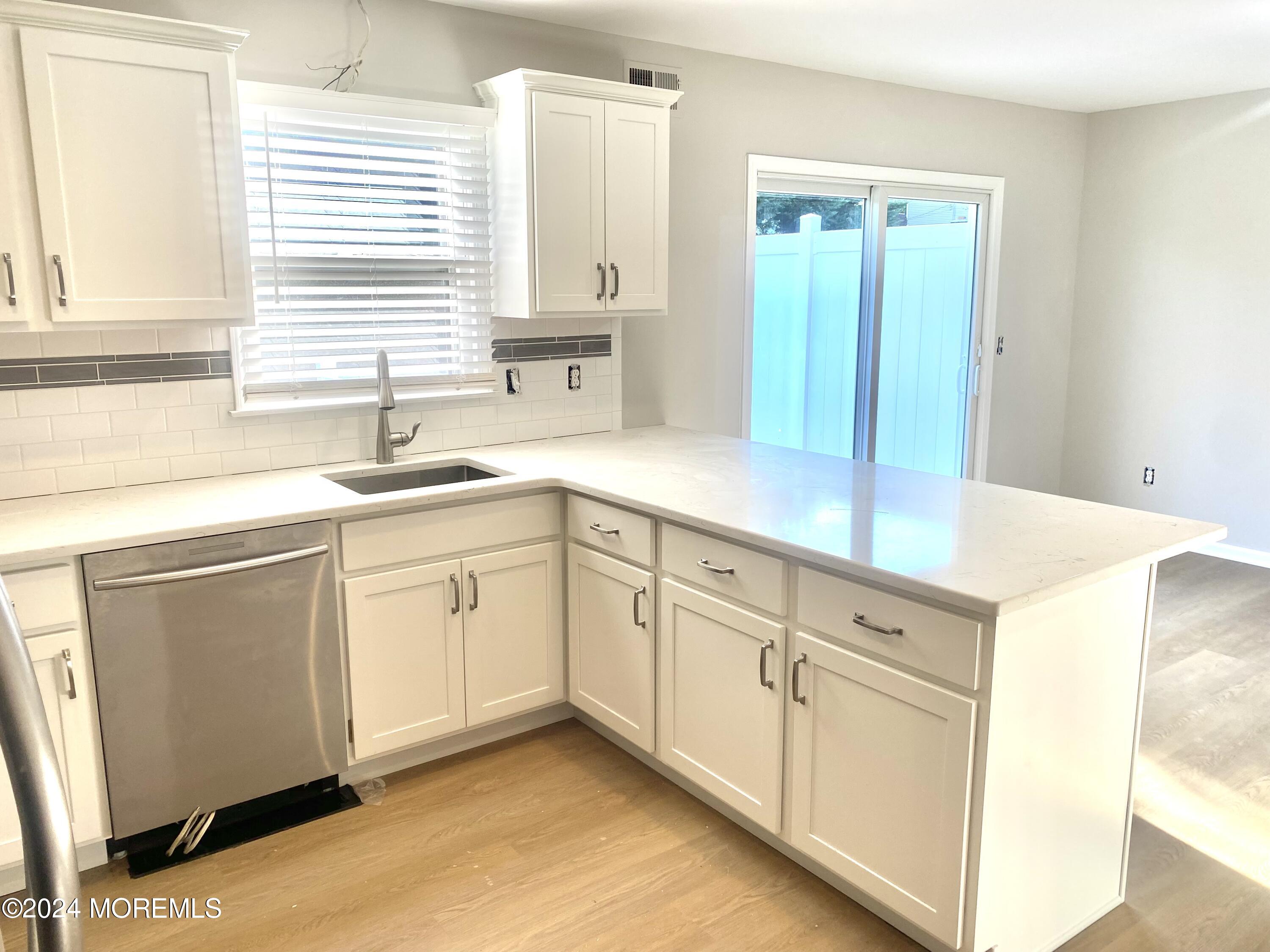 108 Chatham Lane, Unit B Point Pleasant, NJ 08742 - Photo 3 of 14 a kitchen with white cabinets and sink