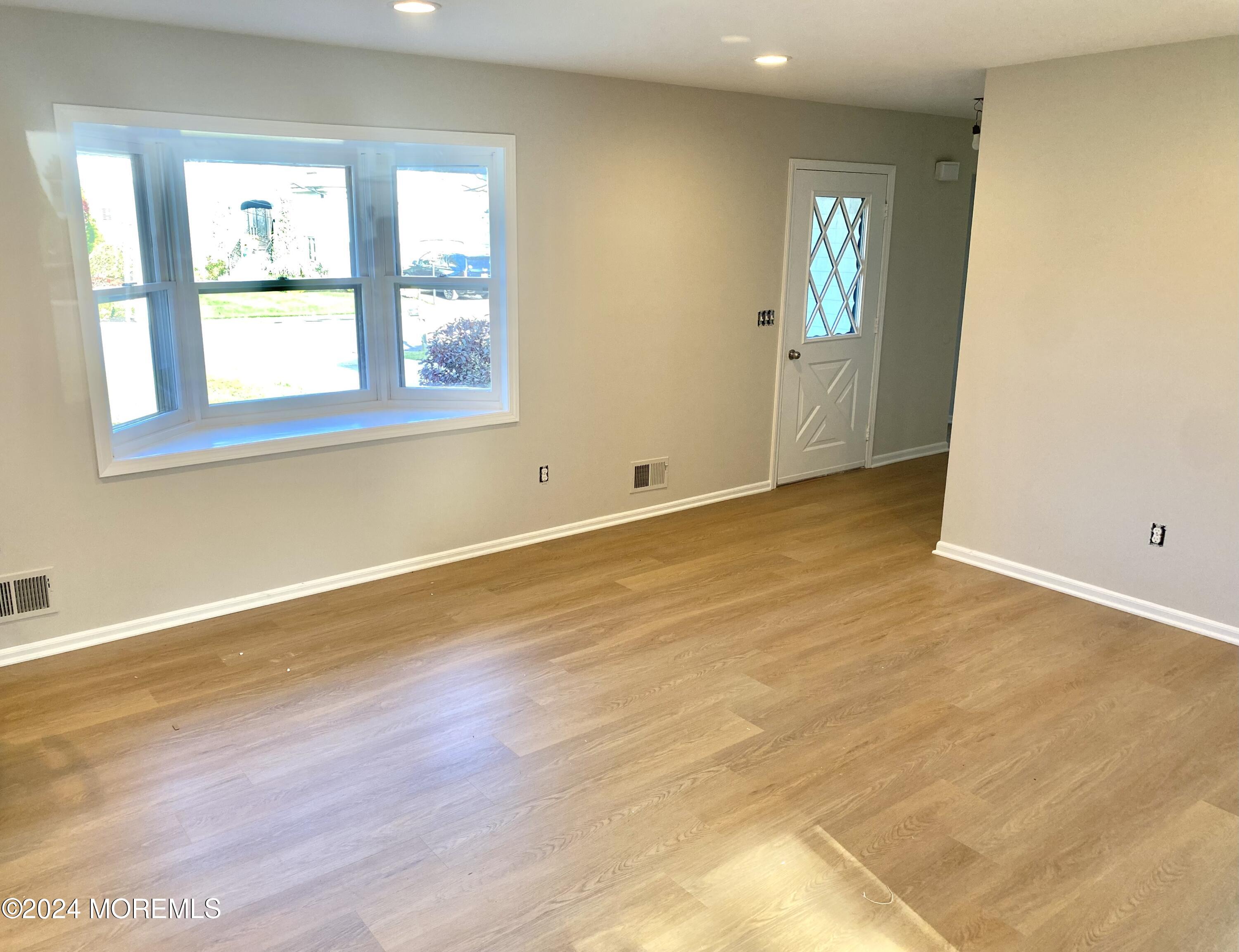 108 Chatham Lane, Unit B Point Pleasant, NJ 08742 - Photo 5 of 14 an empty room with wooden floor and windows