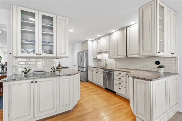 a kitchen with stainless steel appliances granite countertop a sink stove and cabinets