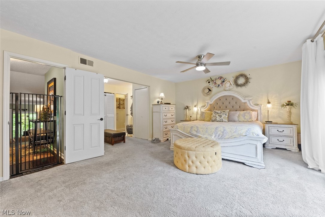 171 Granger Road, Unit 107 Medina, OH 44256 - Photo 23 of 41 Carpeted Master bedroom featuring a ceiling fan with integrated lighting, recessed lighting, and a white interior door overlooking the master bathroom.