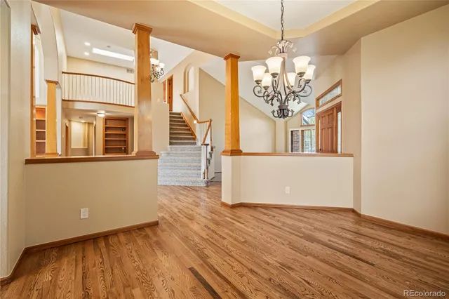 a view of a room with wooden floor and chandelier