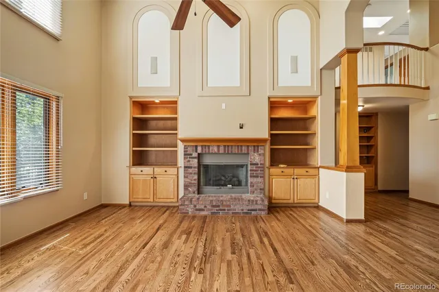 a view of a livingroom with wooden floor and a fireplace