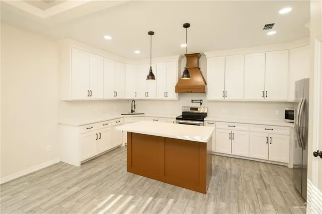 a kitchen with white cabinets appliances and sink