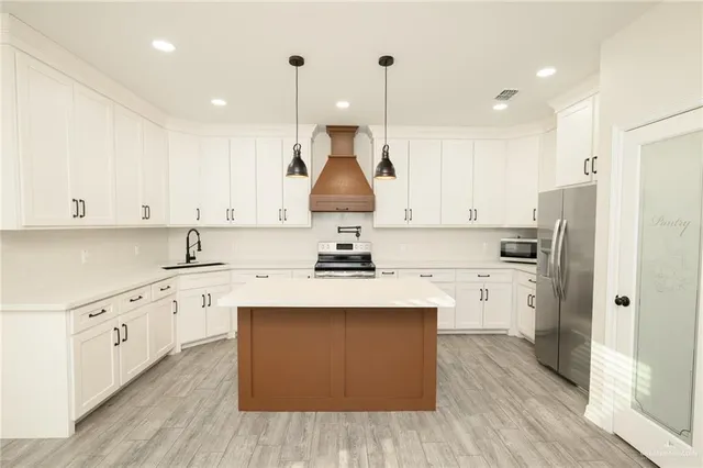 a kitchen with stainless steel appliances granite countertop a sink stove and refrigerator