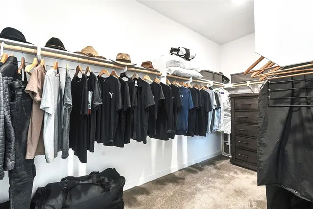 a view of walk in closet with clothes