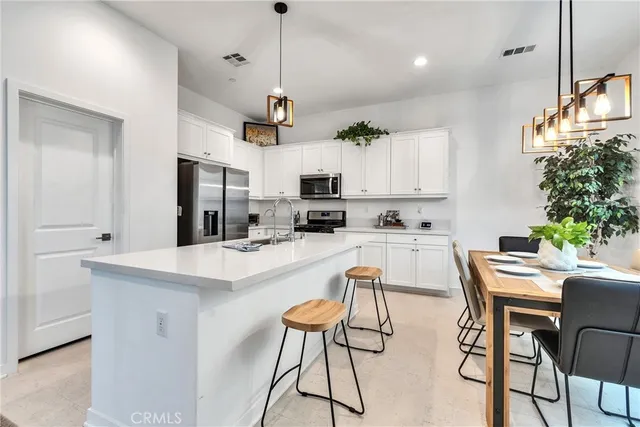 a kitchen with stainless steel appliances kitchen island a refrigerator and a stove top oven