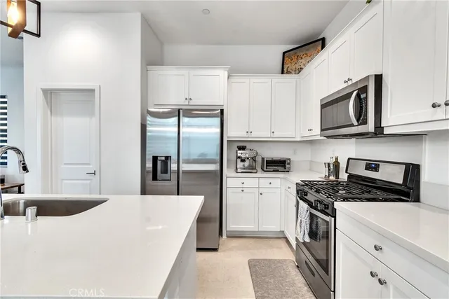 a kitchen with stainless steel appliances granite countertop a refrigerator sink and cabinets