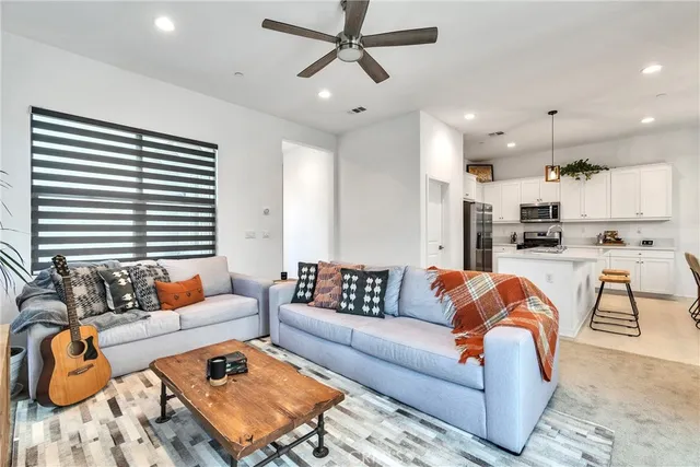 a living room with furniture and kitchen view