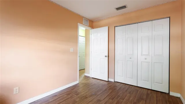 a view of an empty room with wooden floor