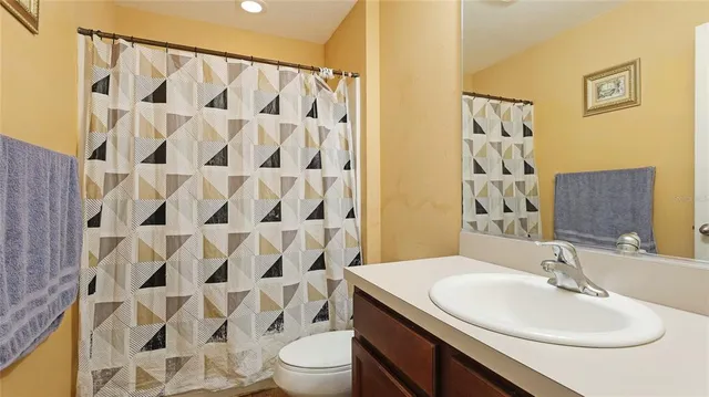 a bathroom with a sink toilet a mirror and shower curtain