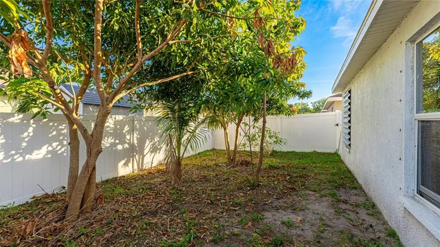 a backyard of a house with lots of plants and tree