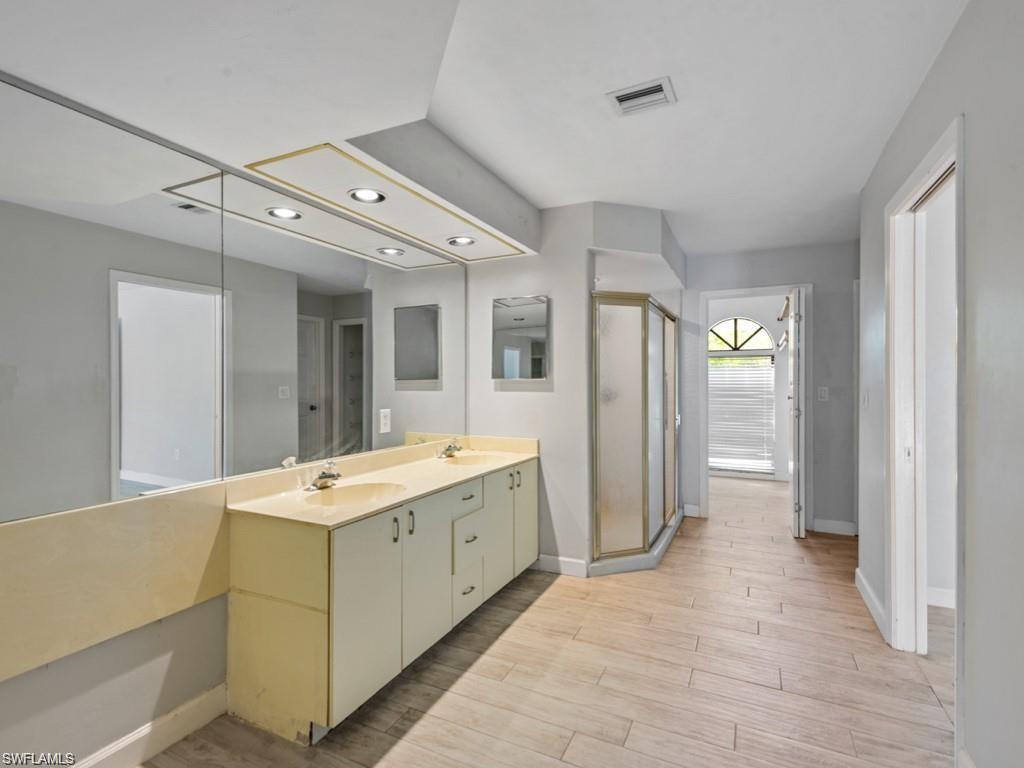 7016 Trail Boulevard Naples, FL 34108 - Photo 13 of 25 a view of a bathroom with a granite countertop sink mirror and bathtub