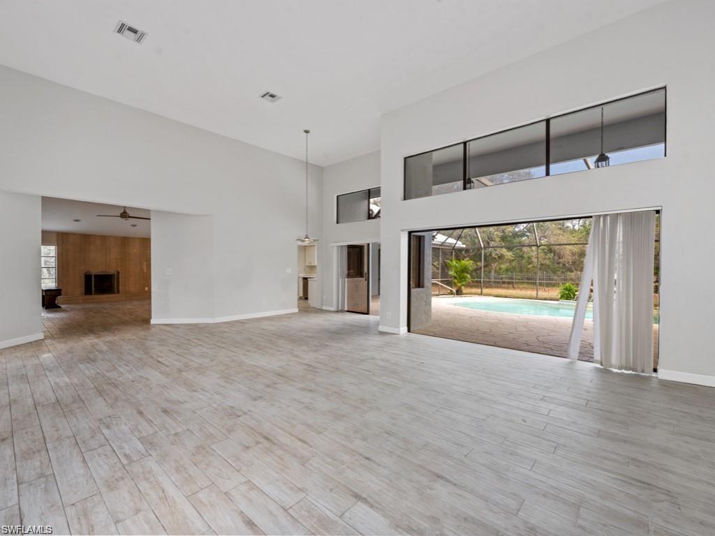 7016 Trail Boulevard Naples, FL 34108 - Photo 3 of 25 a view of an empty room with wooden floor and a window