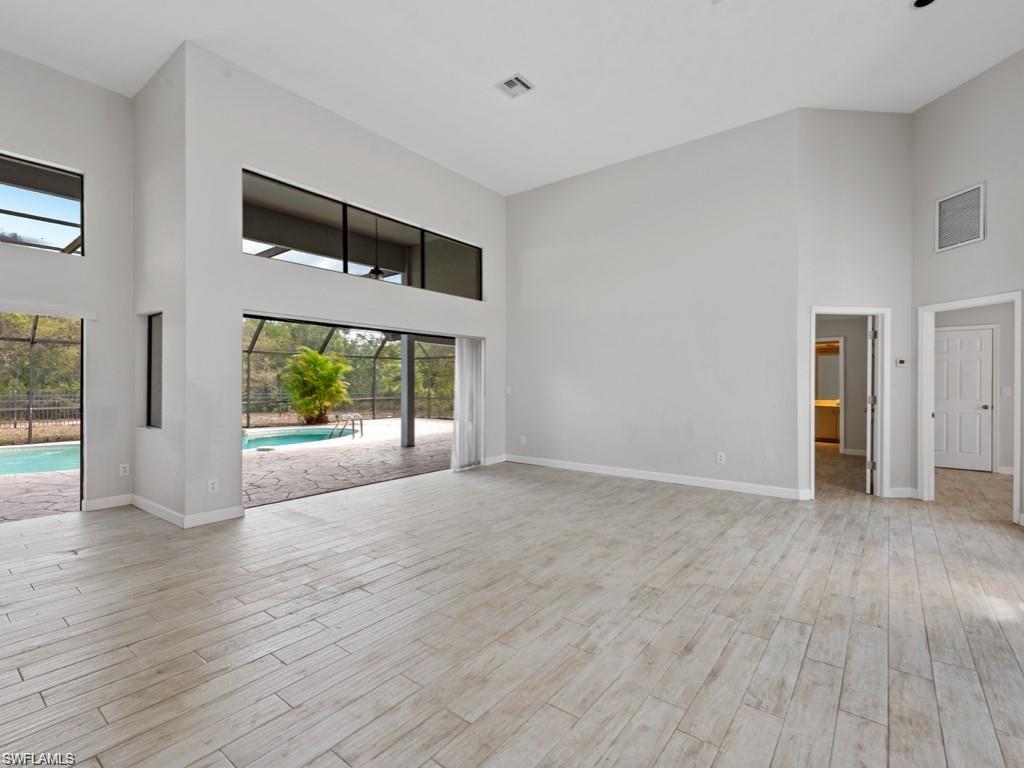 7016 Trail Boulevard Naples, FL 34108 - Photo 4 of 25 a view of an empty room with wooden floor and a window