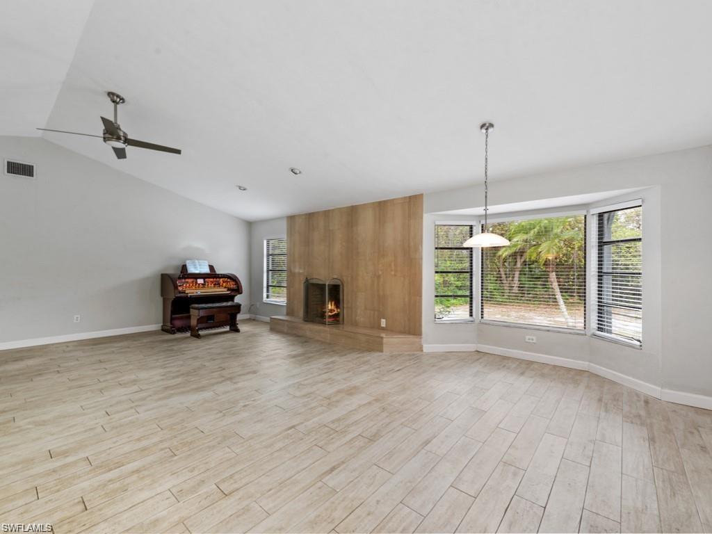 7016 Trail Boulevard Naples, FL 34108 - Photo 8 of 25 a view of a livingroom with furniture fireplace hardwood and a ceiling fan