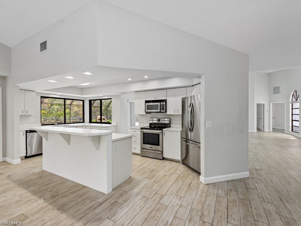 7016 Trail Boulevard Naples, FL 34108 - Photo 10 of 25 a kitchen with a refrigerator and a stove top oven