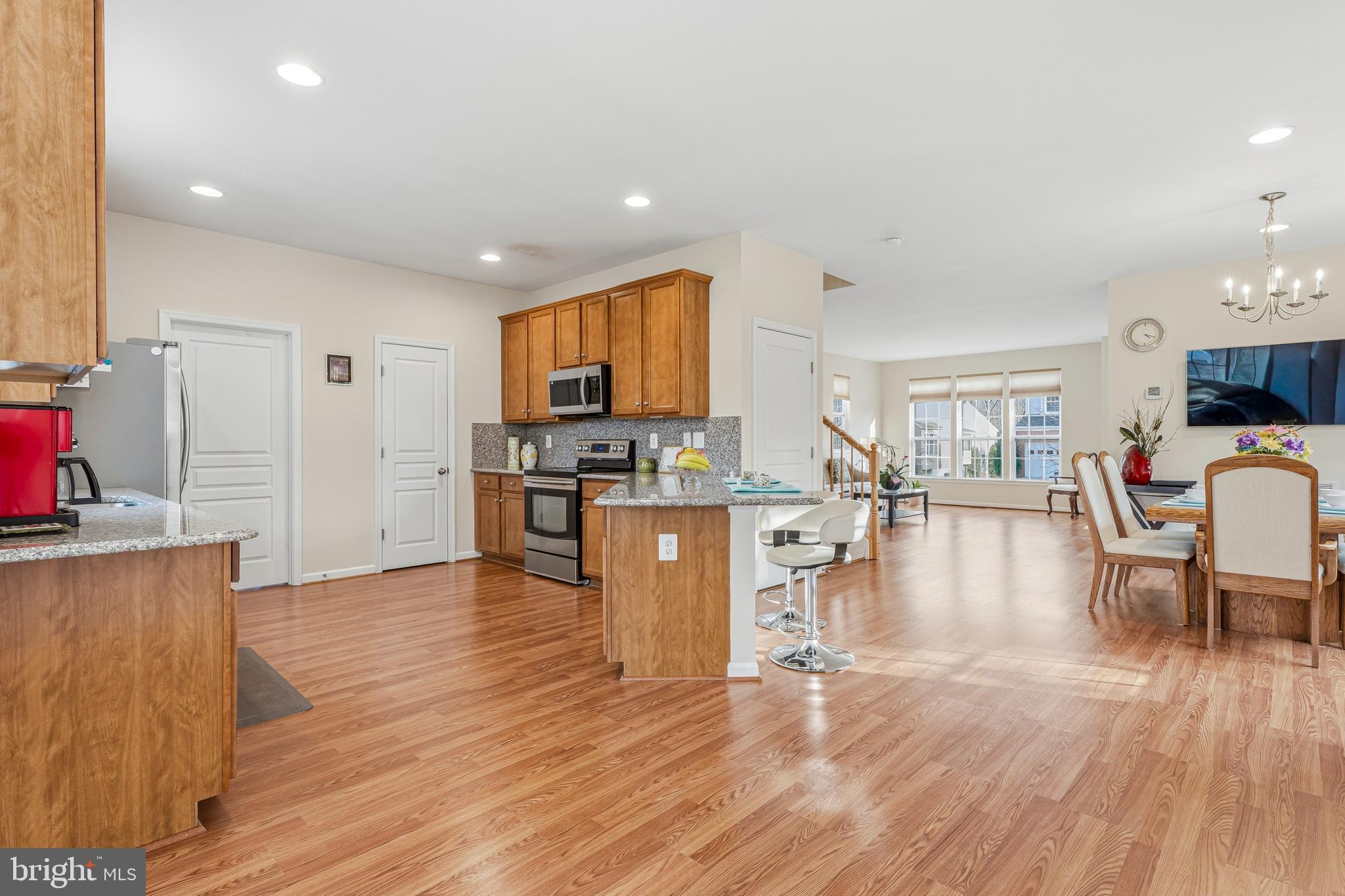 8876 Paddock Lane Baltimore, MD 21234 - Photo 8 of 37 a kitchen with stainless steel appliances kitchen island wooden floors stove and white cabinets