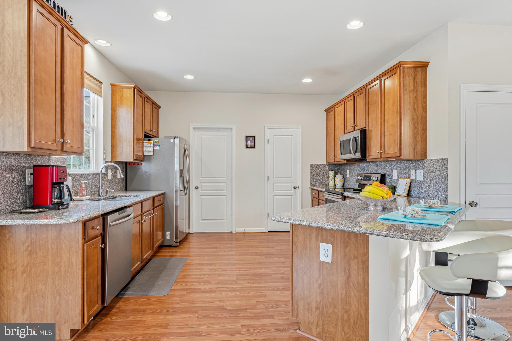 8876 Paddock Lane Baltimore, MD 21234 - Photo 9 of 37 a kitchen with stainless steel appliances granite countertop a sink stove and refrigerator