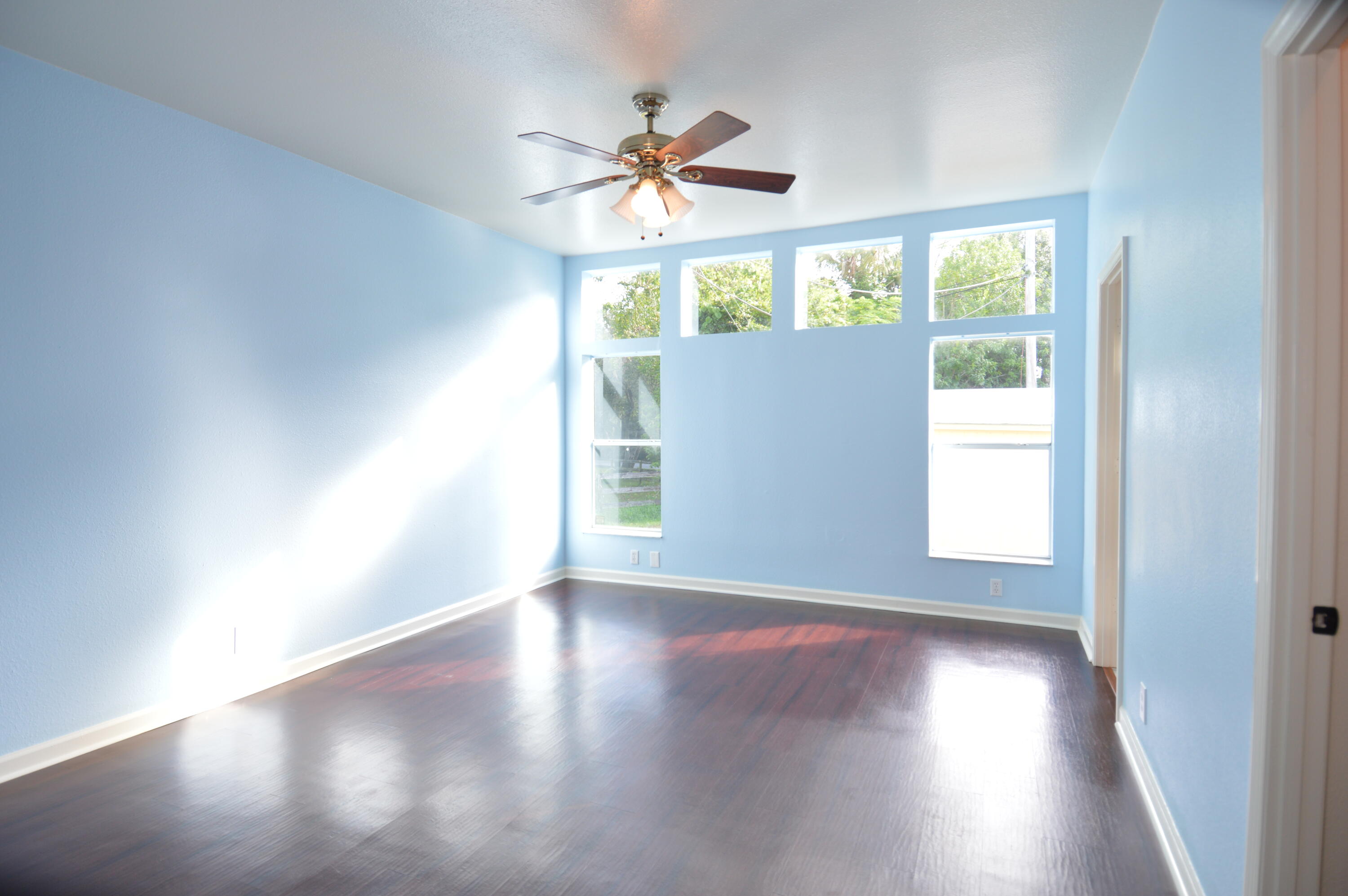 1201 Southwest Sunshine Street Stuart, FL 34997 - Photo 17 of 41 an empty room with wooden floor fan and windows