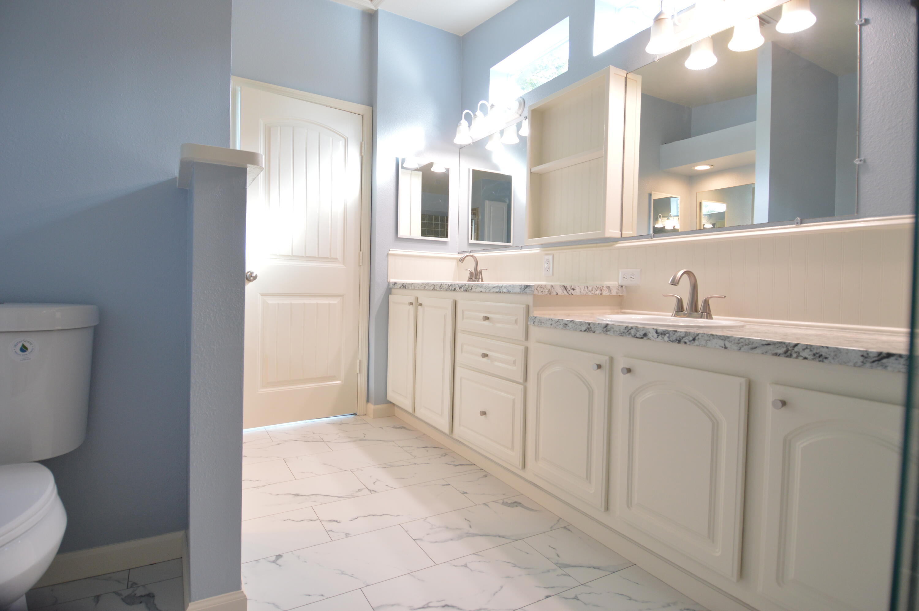 1201 Southwest Sunshine Street Stuart, FL 34997 - Photo 19 of 41 a spacious bathroom with a granite countertop sink a toilet and a mirror