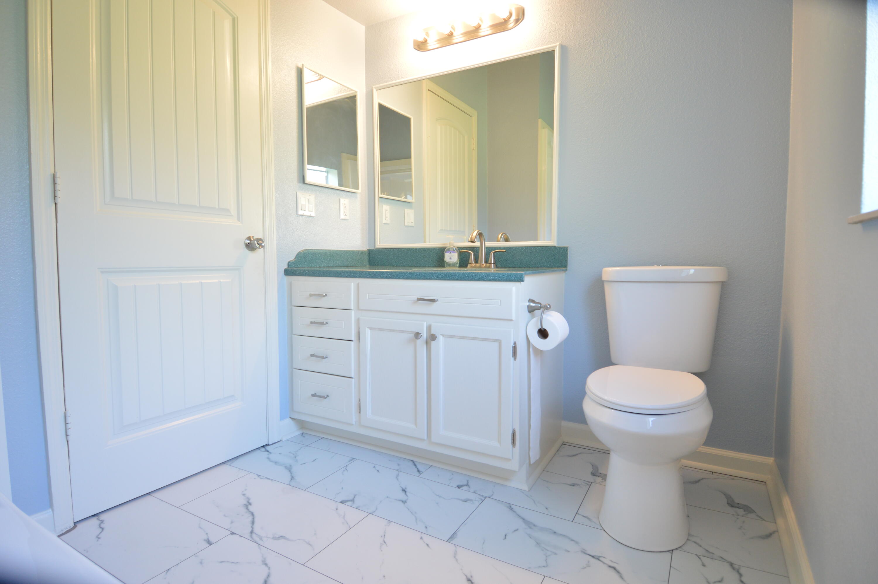 1201 Southwest Sunshine Street Stuart, FL 34997 - Photo 30 of 41 a bathroom with a toilet sink and mirror