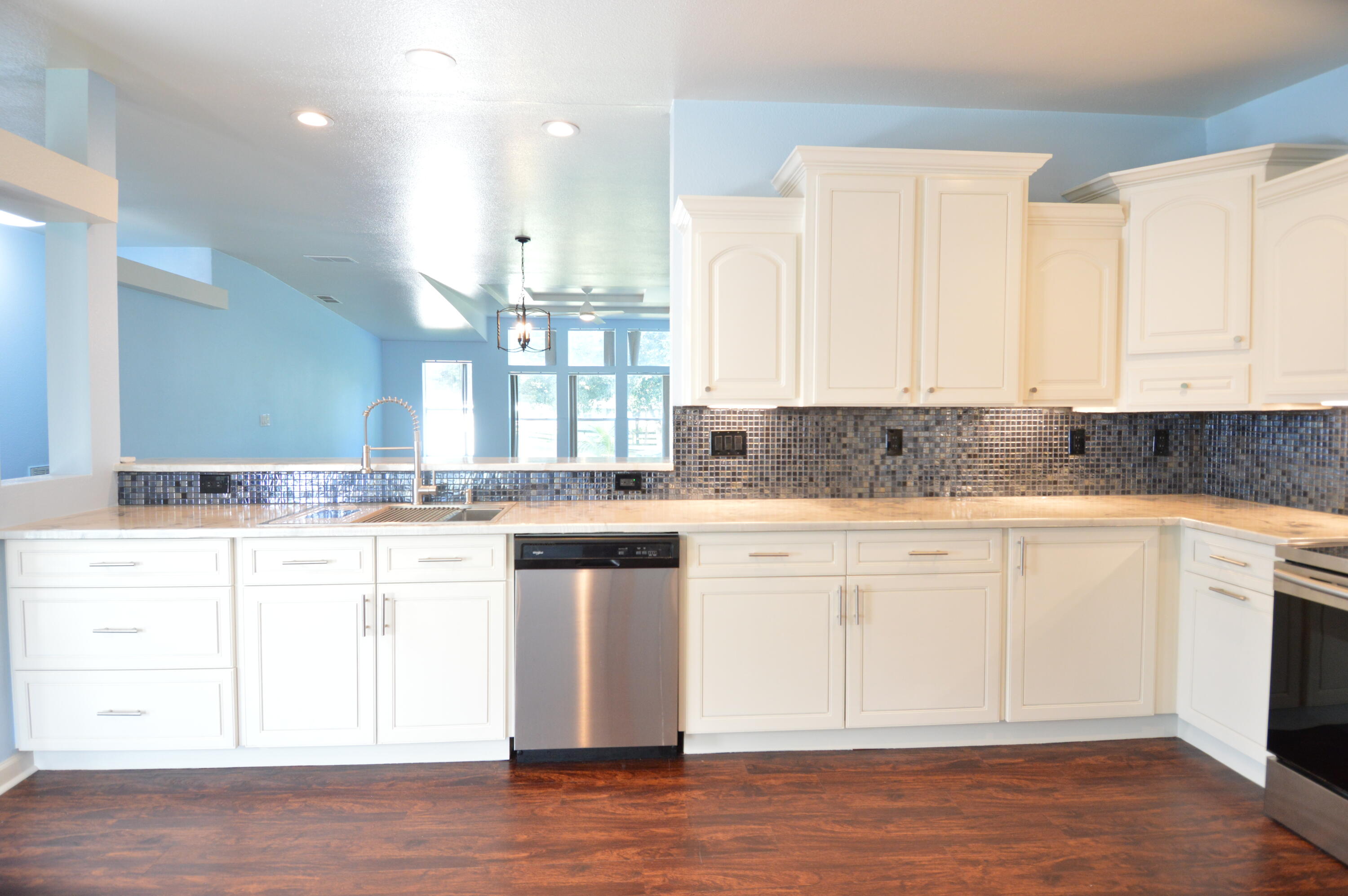 1201 Southwest Sunshine Street Stuart, FL 34997 - Photo 3 of 41 a kitchen with granite countertop white cabinets and white appliances