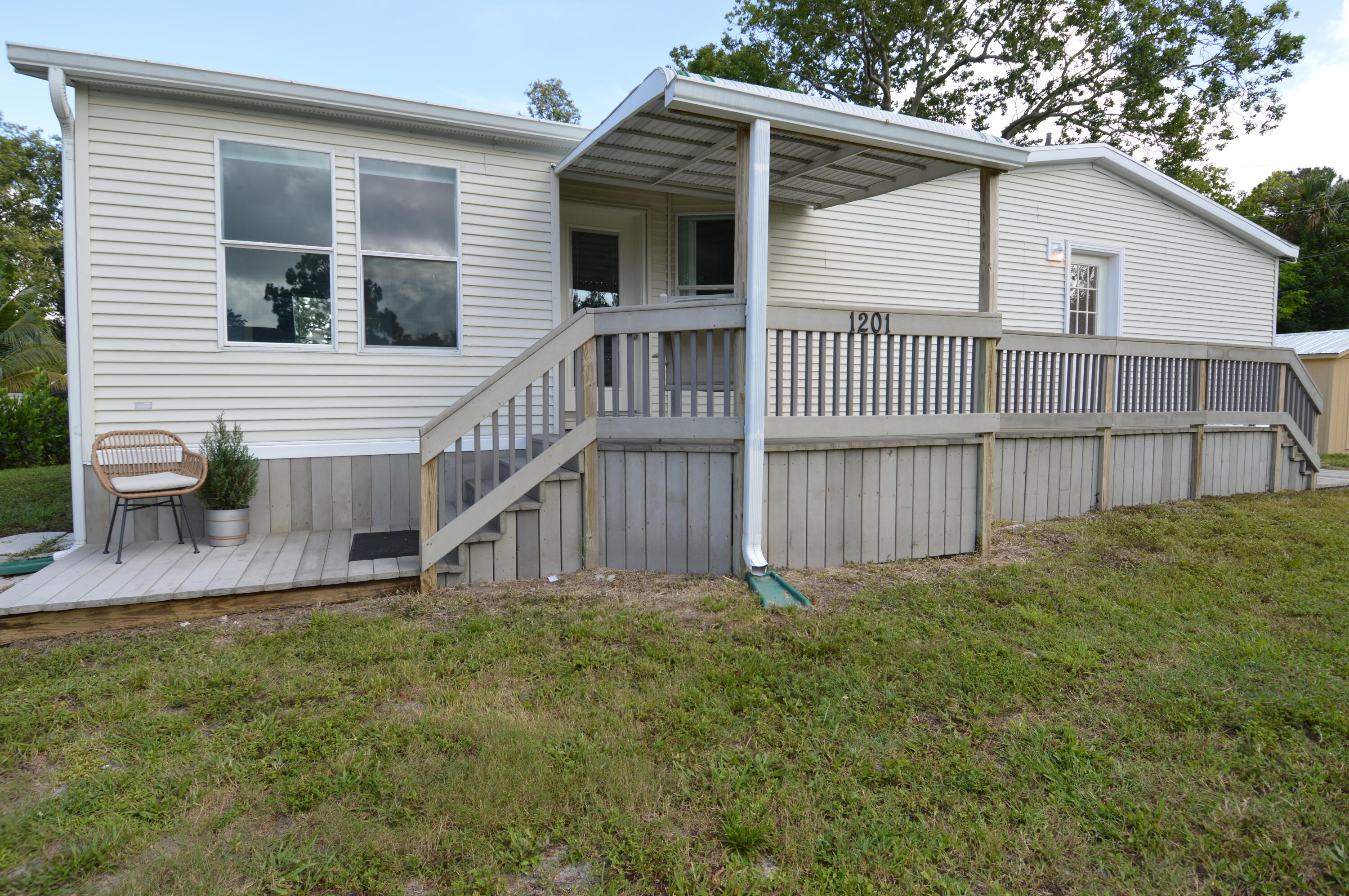 1201 Southwest Sunshine Street Stuart, FL 34997 - Photo 37 of 41 a view of a house with a yard and deck