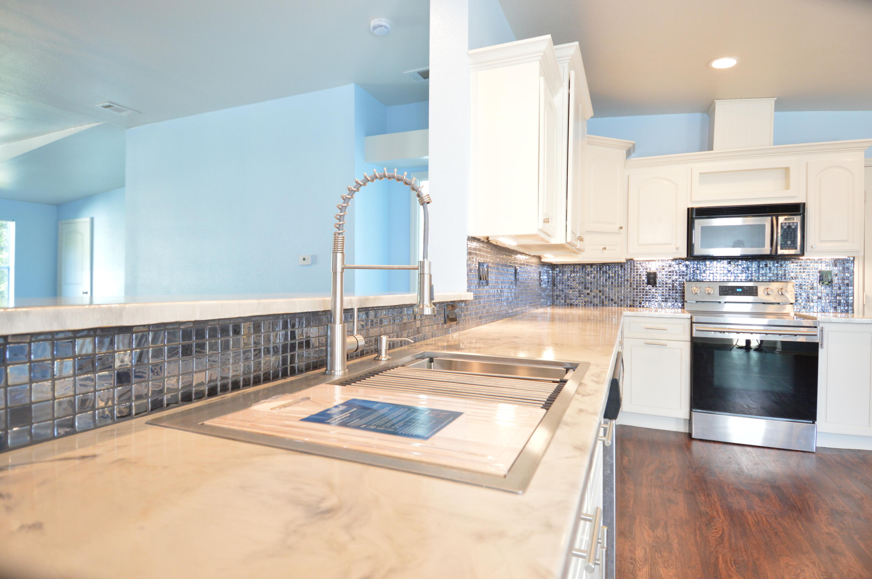 1201 Southwest Sunshine Street Stuart, FL 34997 - Photo 7 of 41 a kitchen with stainless steel appliances granite countertop a stove a sink and a microwave